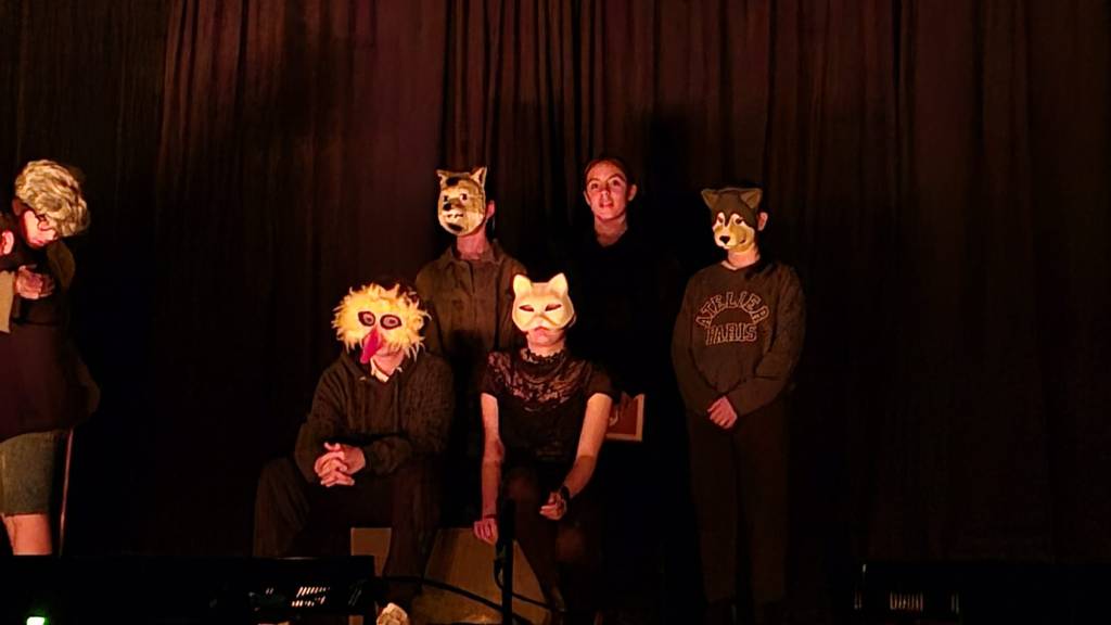 Élèves sur scène portant des masques